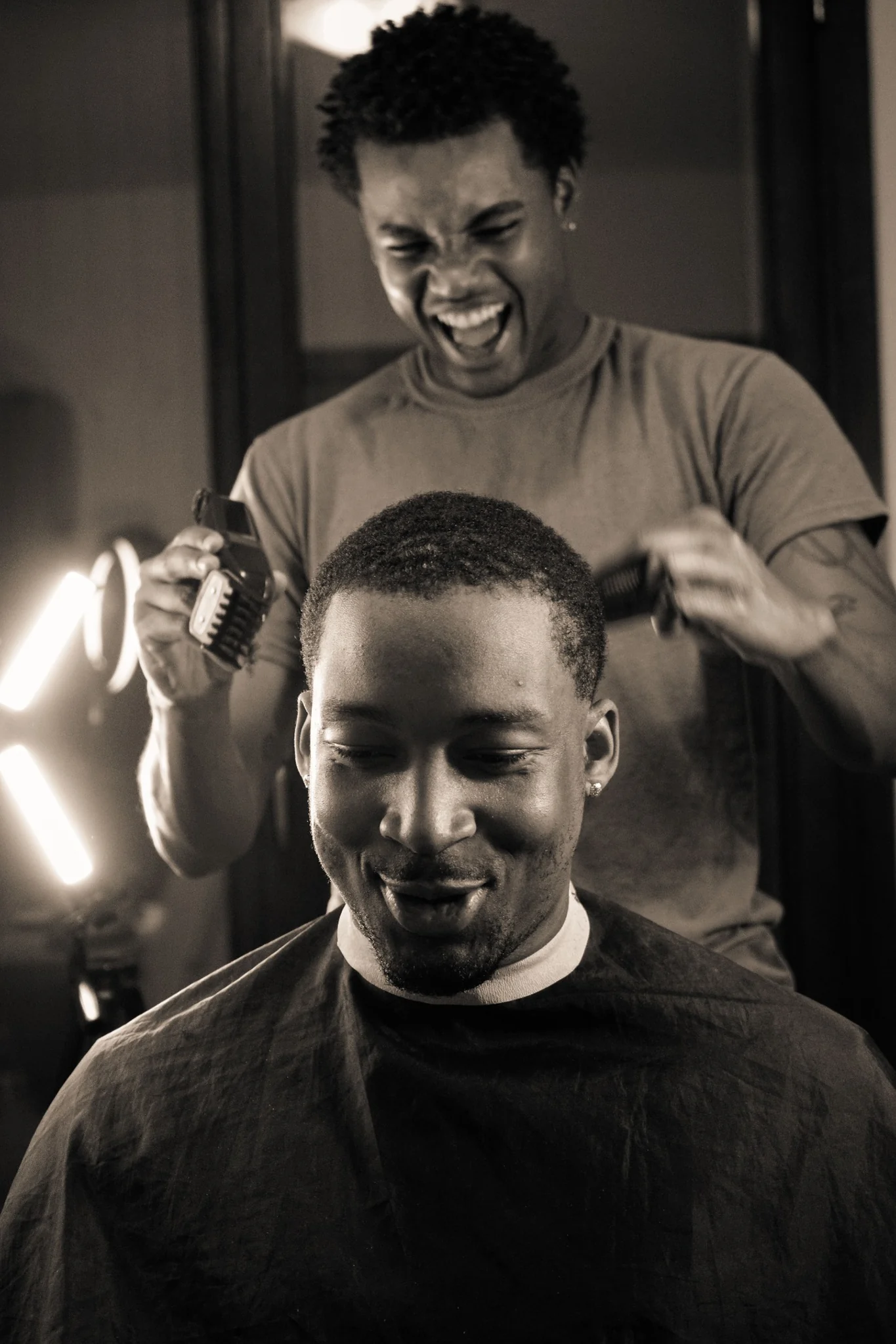 Barber smiling while giving a client a haircut