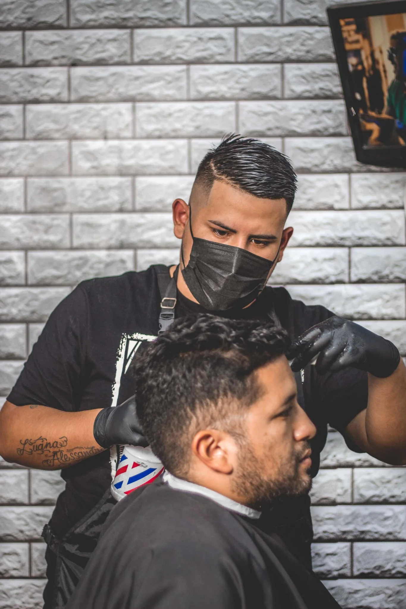 Barber providing a haircut to a seated client.